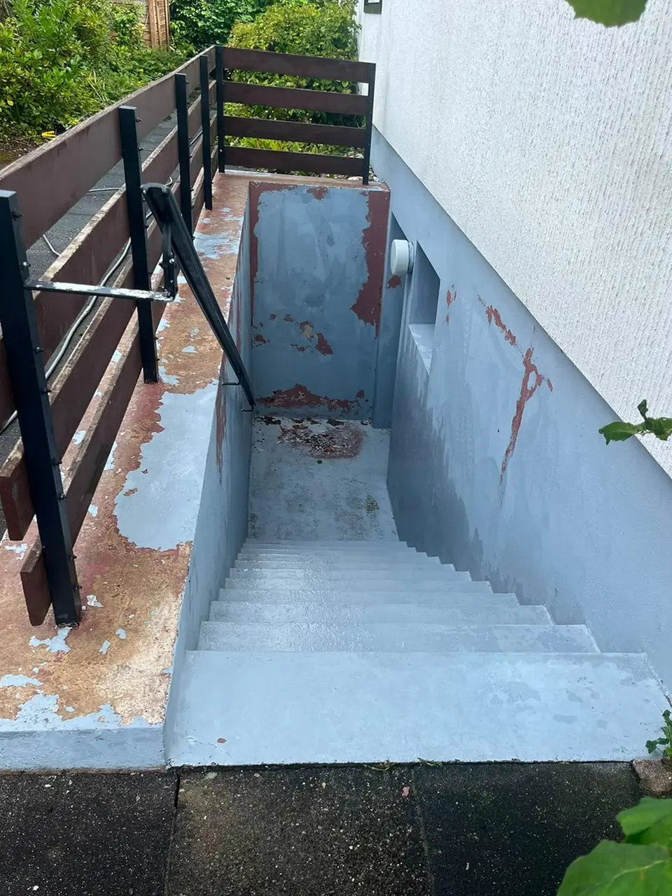 Derselbe Kellerabgang vorher mit abgeplatzter Farbe und rotbraunen Flecken