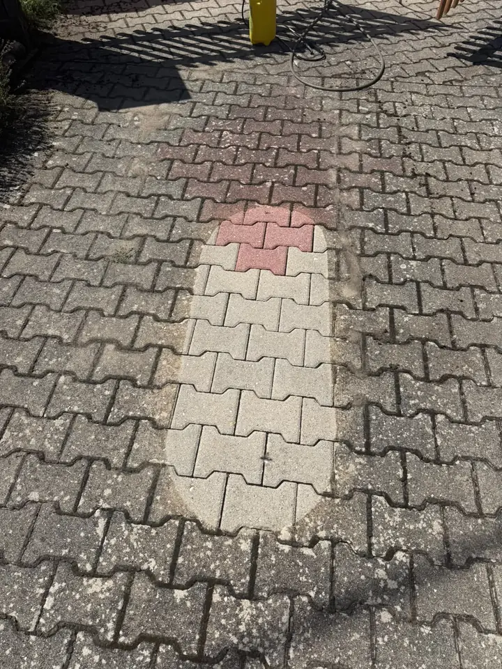 Verbundpflaster mit gereinigter Probefläche, auf der rote und helle Steine wieder zu erkennen sind